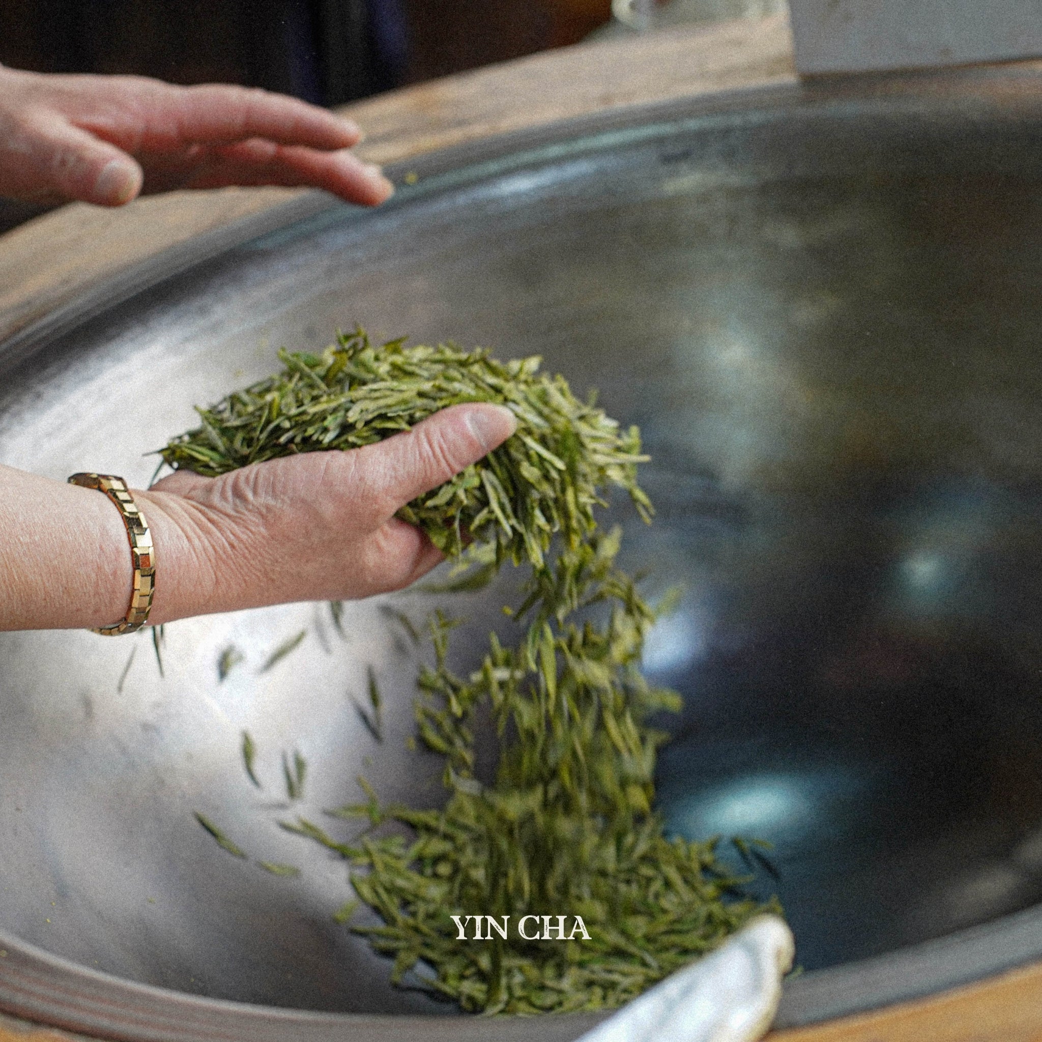 handmaking west lake longjing tea in the wok
