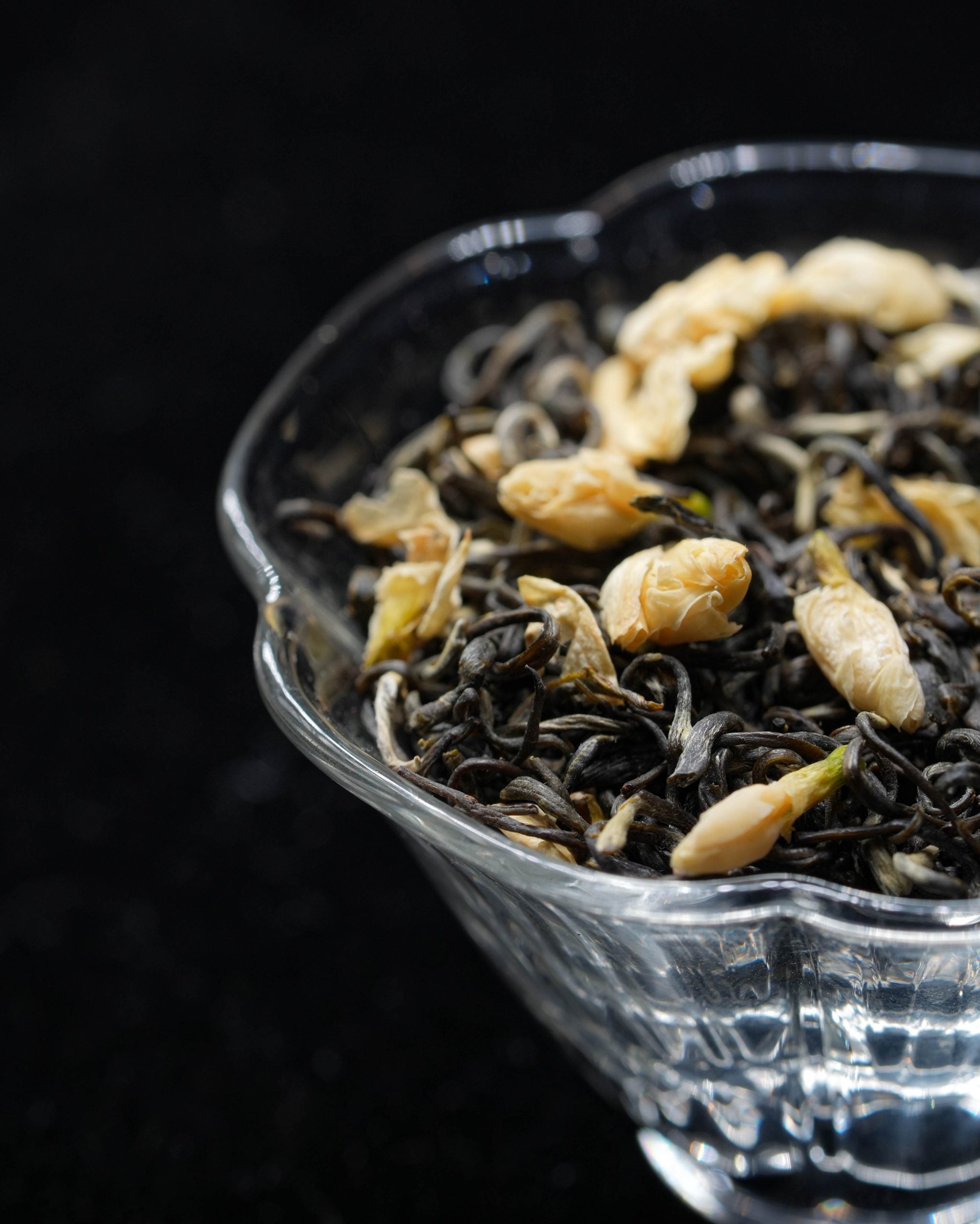 Chinese jasmine green tea dry leaves and flowers in a cu