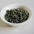 milky oolong dry tea leaves in the small white plate