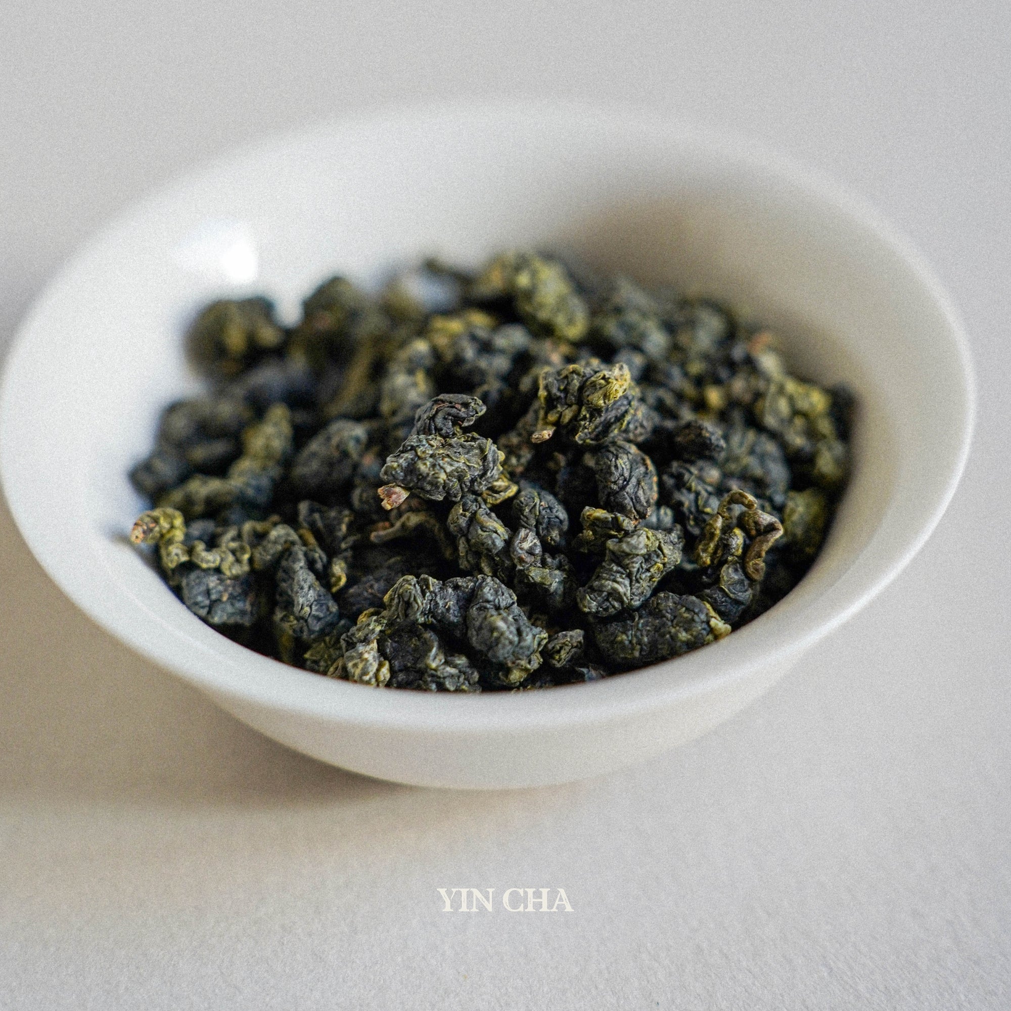 milky oolong dry tea leaves in the small white plate